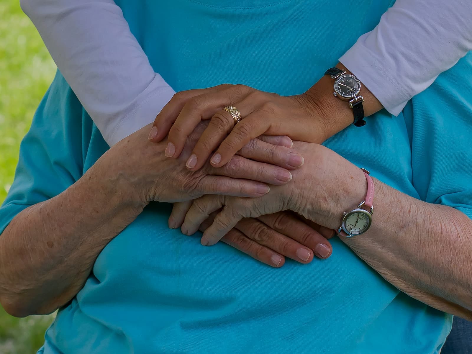 Caregiver and older adult holding hands