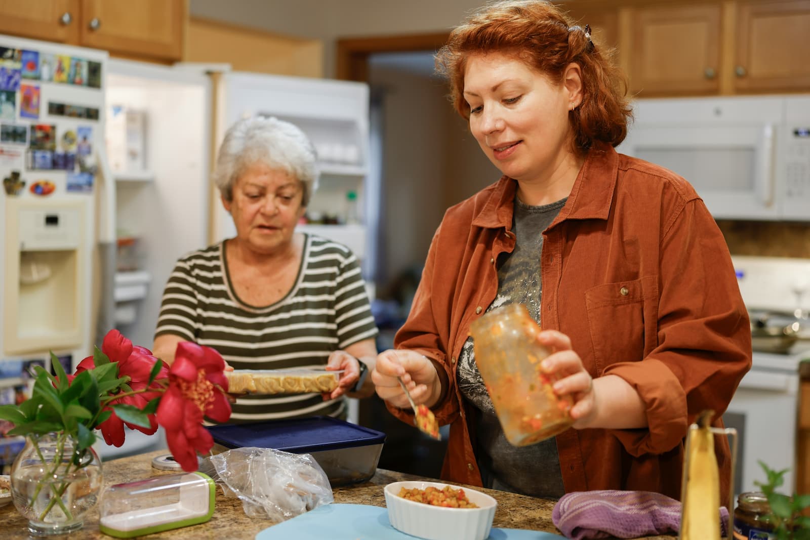 Caregiver helping an older adult prepare a meal at home